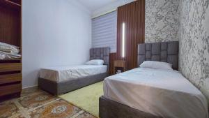 a bedroom with two beds and a window at Central Premium Holiday Homes - Marché, Corniche & Océan à pied in Larache