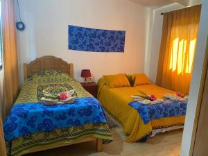 a bedroom with two beds with bowls of food on them at Hostal y Cabañas Pua Vaenga in Hanga Roa
