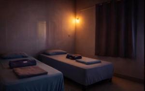 two twin beds in a room withthritisthritislictslictslicts at Casa charmosa familiar in Chapada dos Guimarães
