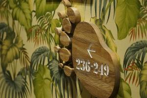 a wooden clock hanging on a wall with plants at La'gent Hotel Osaka Bay in Osaka