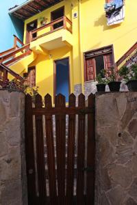 una valla de madera frente a una casa amarilla en Casa da Val, en Morro de São Paulo