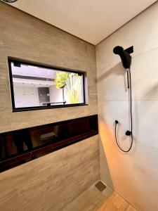 a bathroom with a shower and a window at Super comfortable house 3 bedrooms in Paranavaí +103 photos
