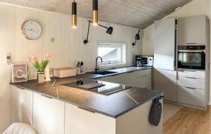 a kitchen with a sink and a clock on the wall at Beautiful Home In Nexø With Sauna in Vester Sømarken