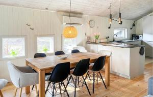 a kitchen and dining room with a wooden table and chairs at Beautiful Home In Nexø With Sauna in Vester Sømarken