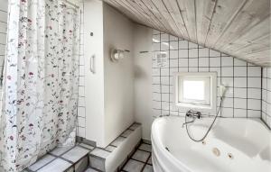 a bathroom with a tub and a shower curtain at Beautiful Home In Nexø With Sauna in Vester Sømarken +12 photos