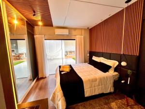 a bedroom with a bed and a large window at Super comfortable house 3 bedrooms in Paranavaí