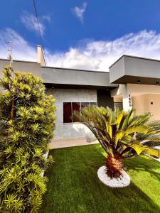 a house with a palm tree in the front yard at Super comfortable house 3 bedrooms in Paranavaí