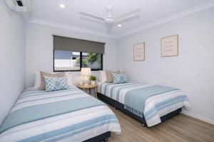 a bedroom with two beds and a window at Golfside Haven 2 Bedroom Duplex with Golf Course in Rosslea