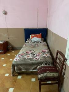 a small bedroom with a bed and a chair at Beit Gedi in Cairo