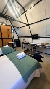 a room with two beds and a desk in a tent at Noite Estrelada Hospedagem Rural & Motorhome Park in Holambra