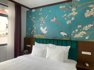 a bedroom with a bed and a painting of birds at Hanoi Central Westlake Hotel in Hanoi +22 photos