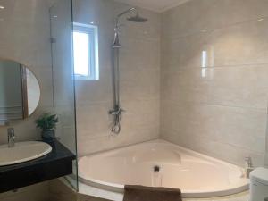 a bathroom with a tub and a sink at Hanoi Central Westlake Hotel in Hanoi