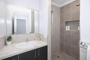 a bathroom with a sink and a mirror at Golfside Haven 2 Bedroom Duplex with Golf Course in Rosslea +4 photos