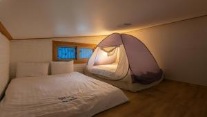 a bedroom with a bed and a tent on the wall at suncheon romance pension in Suncheon