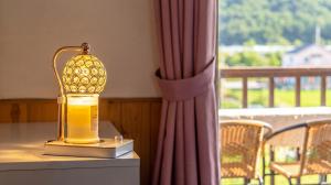 a lantern sitting on top of a table next to a window at suncheon romance pension in Suncheon