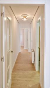 an empty hallway with white walls and wood floors at Piano 8 Sanxenxo in Sanxenxo +5 photos