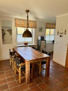 a dining room with a wooden table and chairs at Achtern-Diek-1 in Brösum