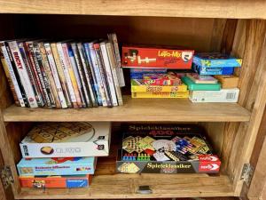 a book shelf filled with games and books at Achtern-Diek-1 in Brösum