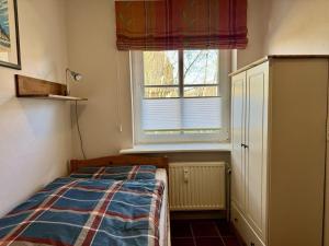 a small bedroom with a bed and a window at Achtern-Diek-1 in Brösum