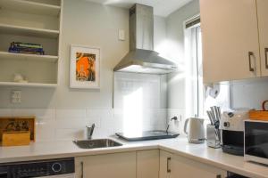a kitchen with a sink and a stove at Stylish Lyttelton Studio Free Parking in  Lyttelton