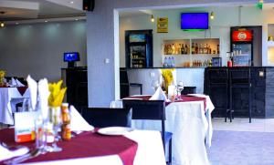 a restaurant with two tables with red and white table cloth at Riviera Kivu View in Gisenyi