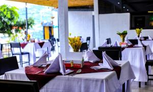 a dining room with white tables and white napkins at Riviera Kivu View in Gisenyi