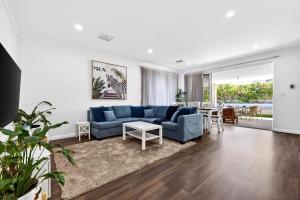 a living room with a blue couch and a table at DEAR8 - Madeley Retreat in Perth