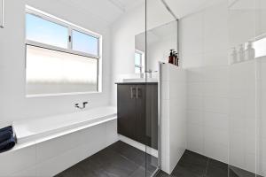 a white bathroom with a tub and a window at DEAR8 - Madeley Retreat in Perth +19 photos