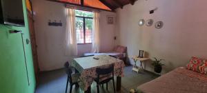 a room with a table and a bed and a window at OASIS II Las Moras, con cochera y jardin in La Rioja