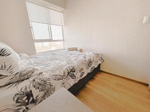 a small bedroom with a bed and a window at Apacible y acogedora habitación con vista a Barranco in Lima +26 photos