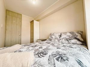 a bedroom with a bed with a comforter on it at Apacible y acogedora habitación con vista a Barranco in Lima