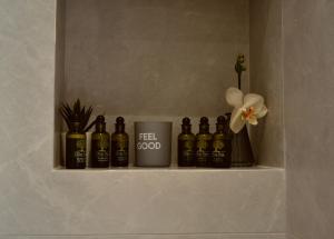 a shelf with bottles of alcohol and a flower at 7th Heaven Luxury Villa in Kallithea Halkidikis