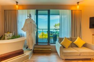 a living room with a bath tub and a couch at Coconut Tree Hulhuvilla Beach in Hulhumale