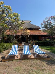 three lounge chairs and a table in front of a house at Habitacion Sol in Puerto Escondido