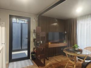 a living room with a table and a television at Huruhuru Hideaway! Private Cabin in Otatara