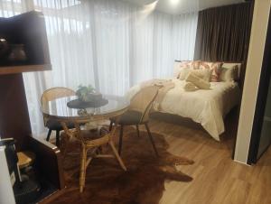 a bedroom with a bed and a table and a tableablish at Huruhuru Hideaway! Private Cabin in Otatara