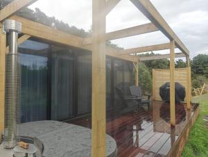 a house with glass walls and a deck at Huruhuru Hideaway! Private Cabin in Otatara