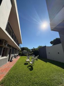 a row of chairs sitting on a lawn next to a building at YOJU aparthotel in Colón