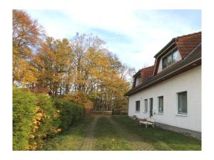 a white house with a bench in the yard at Deichblick 02 in Prerow