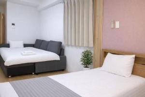 a room with two beds and a couch at 桜の恋 in Osaka