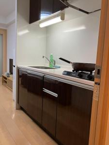 a kitchen with a stove and a sink at 桜の恋 in Osaka