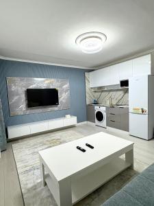 a kitchen with a white table and a white refrigerator at Gegee's House in Ulaanbaatar
