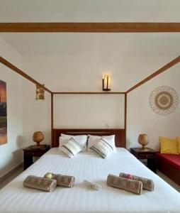 a bedroom with a large white bed with two pillows at La Fontaine de Tara Boutique Hotel in Siem Reap