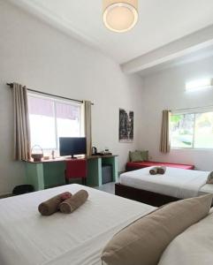 a room with two beds and a desk with a computer at La Fontaine de Tara Boutique Hotel in Siem Reap