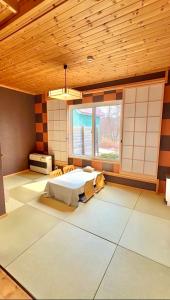 a large room with a bed and a window at Auberge Ninguruforet in Biei