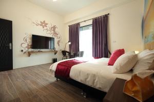 a hotel room with a bed and a tv at Mr Lee Elevator B&B Hualien- Near Dongdamen Night Market in Ji'an