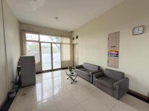 a living room with two couches and a table at Guesthouse Anggrek BSD Syariah in Jombang-kulon