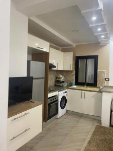 a kitchen with a stove and a dishwasher at Chez montasser in Al Maqārisah