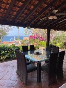 a table and chairs on a patio with a view of the ocean at Casa Bella in Puerto Escondido