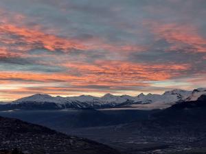 a sunset over a mountain range with snow covered mountains at Sunny chalet in Veysonnaz for 10 guests in Veysonnaz